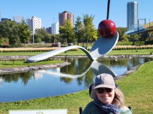 woman wi th a baseball cap on in front of Spoonbridge and Cherry sculpture in Minneapolis