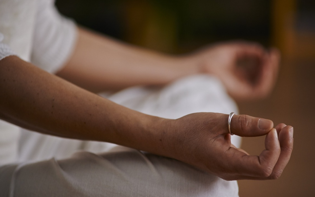 soft-focus of a woman posing with hands on knees to represent that yoga is disability-friendly.